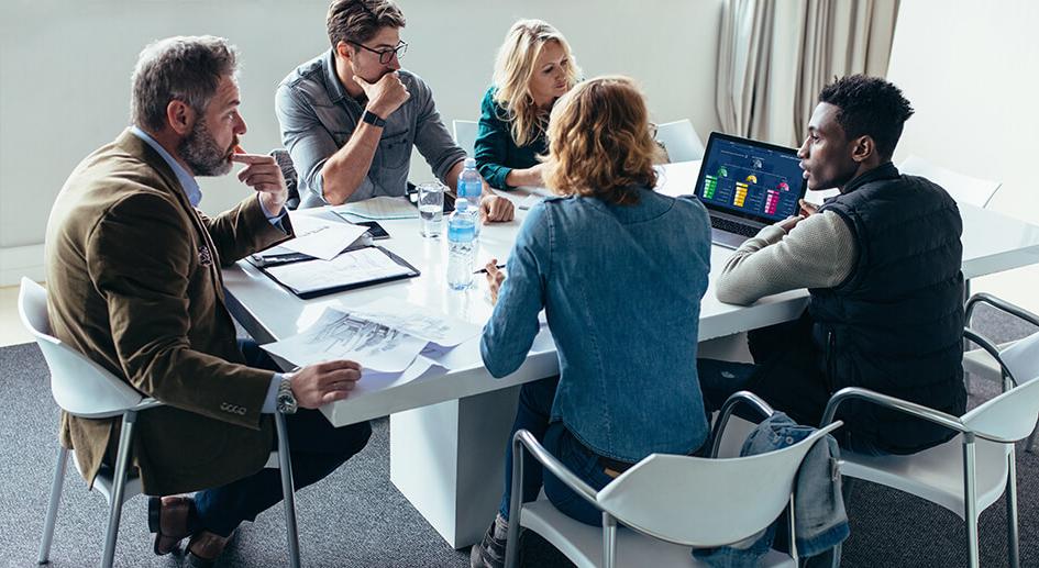 Team of five people working together around a meeting table